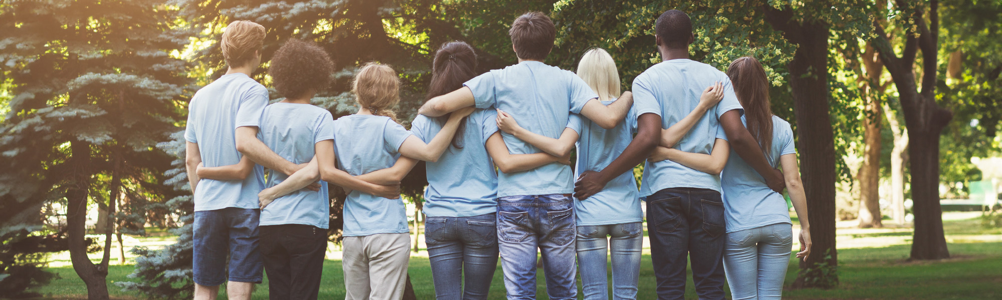 group of millennials volunteers embracing in park